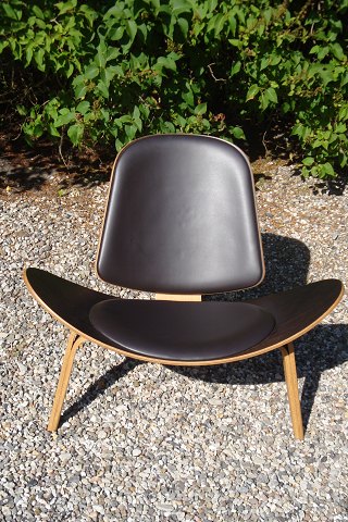 CH07 skalstolen
Designet af Hans Wegner i egetræ med mørkebrun læder i fin stand 
5000 m2 udstilling