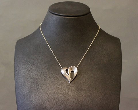 Vedhæng i form af et hjerte i sølv og stemplet SJ.
5000m2 udstilling.