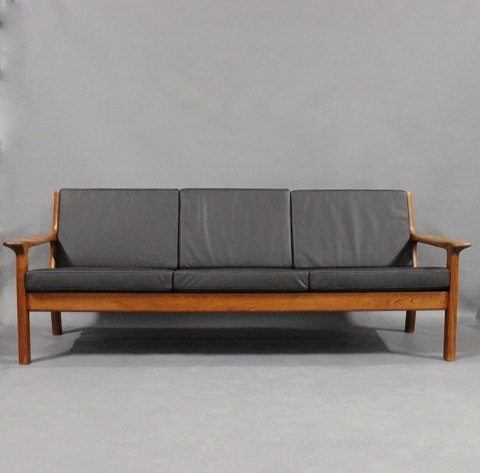 Tre personers sofa i teak og med hynder af sort læder af Juul Kristensen og 
Glostrup Møbelfabrik.
5000m2 udstilling.