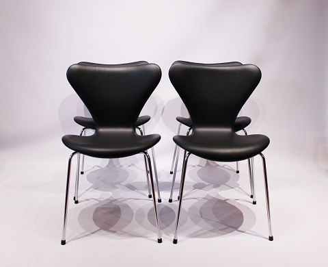 Et sæt af 4 Syver stole, model 3107, i sort klassisk læder  af Arne Jacobsen og Fritz Hansen. 5000m2 udstilling.