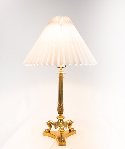 Høj bordlampe i poleret messing med flot udsmykket trefod fra 1920erne.
5000m2 udstilling.