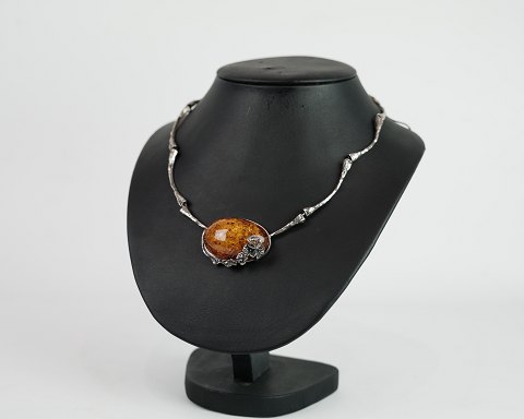 Neck collie in silver with large polished amber lump adorned with silver flowers
Great condition
