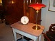 PH bordlampe jubilærumsmodel 3/2 i messing med røde metal skærme 5000 m2 
udstilling