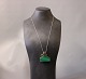 Silver chain with a large pendant with a green stone.
5000m2 showroom.